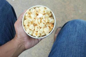 mannen Holding een kom van popcorn top visie foto