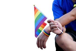 regenboog vlag holing in hand- van Aziatisch homo welke draagt regenboog polsbandje naar telefoontje uit en shows lgbt geslacht verscheidenheid en met inachtneming van geslacht alternatief in de omgeving van de wereld. foto