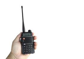 een portable radio zender Holding in hand, wazig een buitenshuis gebouw welke is bouwen, zacht en selectief focus. foto