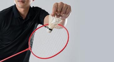 een badminton speler in sportkleding staat Holding een racket en shuttle foto
