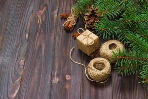Kerstmis Cadeau doos en Spar takken met kaneel en anijs Aan rustiek houten achtergrond. vlak leggen. seizoensgebonden groeten concept. winter vakantie foto