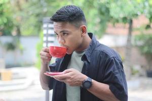 Aziatisch jong Mens drinken koffie in de ochtend- foto