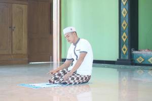 jong Aziatisch moslim bidden in de moskee foto