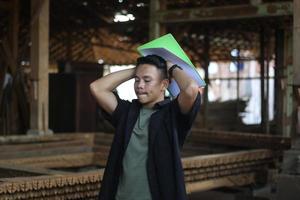 Aziatisch jong Mens baas van hout bedrijf verward controle kwaliteit foto