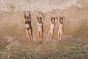 vier vrouw vrienden genieten van de strand foto