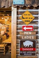 divers uithangborden Aan houten muur van restaurant Bij yellowstone nationaal park foto
