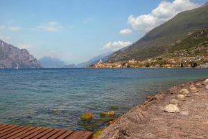 visie van oever van het meer loopbrug naar beroemd mediterraan stad- malcesine, lago di Garda Garda meer, Italië foto