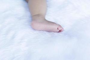 klein kind voeten Aan wit beddengoed. foto
