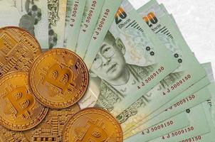 20 Thais baht rekeningen en gouden bitcoins. cryptogeld investering concept. crypto mijnbouw of handel foto