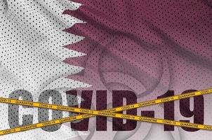 qatar vlag en covid-19 opschrift met oranje quarantaine grens plakband. coronavirus of 2019-ncov virus concept foto