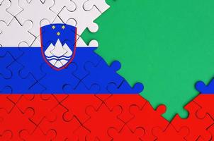 Slovenië vlag is afgebeeld Aan een voltooid decoupeerzaag puzzel met vrij groen kopiëren ruimte Aan de Rechtsaf kant foto