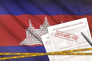 Cambodja vlag en Gezondheid verzekering beweren het formulier met covid-19 stempel. coronavirus of 2019-ncov virus concept foto