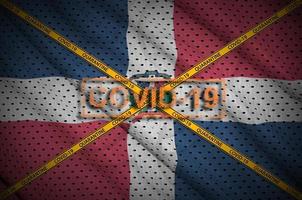 dominicaans republiek vlag en covid-19 postzegel met oranje quarantaine grens plakband kruis. coronavirus of 2019-ncov virus concept foto