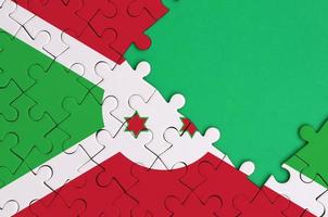 Burundi vlag is afgebeeld Aan een voltooid decoupeerzaag puzzel met vrij groen kopiëren ruimte Aan de Rechtsaf kant foto