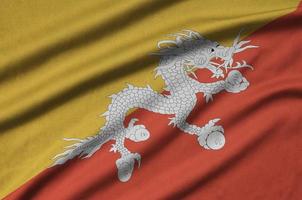 Bhutan vlag is afgebeeld Aan een sport- kleding kleding stof met veel vouwen. sport team banier foto