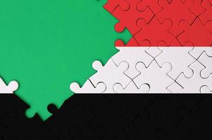 Jemen vlag is afgebeeld Aan een voltooid decoupeerzaag puzzel met vrij groen kopiëren ruimte Aan de links kant foto