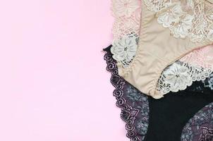 wit, zwart en roze Dames ondergoed met kant Aan roze achtergrond met kopiëren ruimte. reclame voor winkel van mooi en comfortabel Dames ondergoed foto