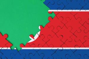 noorden Korea vlag is afgebeeld Aan een voltooid decoupeerzaag puzzel met vrij groen kopiëren ruimte Aan de links kant foto