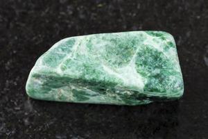 gepolijst groen jadeïet steen Aan donker achtergrond foto