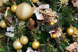 decoreren Kerstmis boom dichtbij omhoog. decoratie lamp, groen Spar boom, gouden Kerstmis speelgoed en lichten. gebruik voor Kerstmis en nieuw jaren viering achtergrond foto