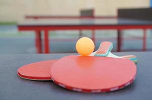rackets en bal Aan ping pong tafel in buitenshuis sport tuin. actief sport- en fysiek opleiding concept foto