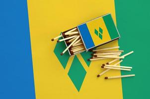 heilige vincent en de grenadines vlag is getoond Aan een Open luciferdoosje, van welke meerdere wedstrijden vallen en leugens Aan een groot vlag foto