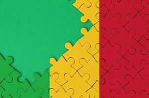 Mali vlag is afgebeeld Aan een voltooid decoupeerzaag puzzel met vrij groen kopiëren ruimte Aan de links kant foto