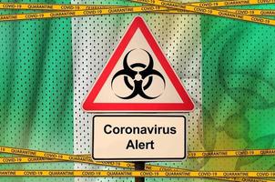 Nigeria vlag en covid-19 biohazard symbool met quarantaine oranje plakband. coronavirus of 2019-ncov virus concept foto