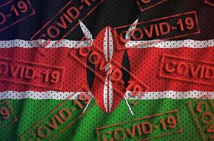 Kenia vlag en veel rood covid-19 postzegels. coronavirus of 2019-ncov virus concept foto