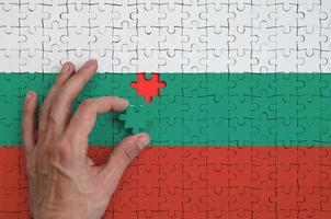 bulgarije vlag is afgebeeld Aan een puzzel, welke de man's hand- voltooit naar vouwen foto