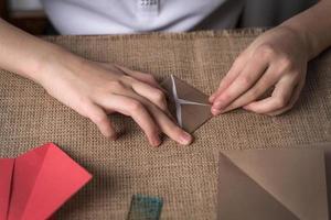 een meisje maakt origami uit van gekleurde papier foto