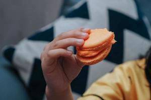 een kind hand- Holding een macarons foto