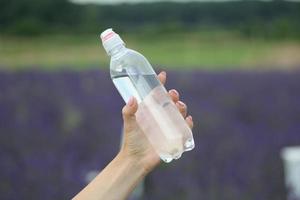 hand met een fles water foto