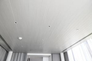 geschorst plafond met halogeen vlekken lampen en gipsplaat bouw in leeg kamer in appartement of huis. rekken plafond wit en complex vorm foto