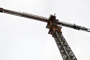 groot krachtig bouw lading industrieel kraan Aan een bouw plaats van nieuw gebouwen en huizen tegen de lucht foto