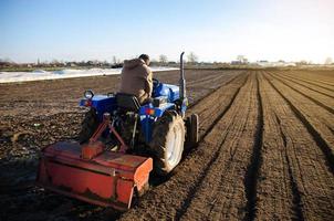 een boer is cultiveren de boerderij veld. seizoensgebonden arbeider. rekruteren arbeiders met het rijden vaardigheden van agrarisch machines. werk in de agrarisch industrie. land- teelt. landbouw. klein boerderijen. foto