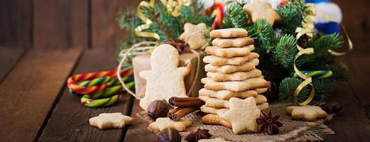 Kerstmis koekjes en klatergoud Aan een houten achtergrond foto