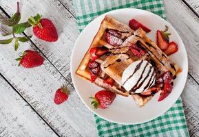 belgie wafels met aardbeien en ijs room Aan wit bord foto