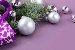 de concept van een Kerstmis achtergrond. top visie van zilver ballen van een Kerstmis geschenk doos met Spar takken Aan een modieus Purper achtergrond. foto