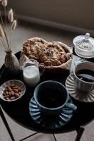 esthetisch ontbijt. melk koffie, melk thee, suiker, amandel, amandel taarten, koekjes, marsepeinen en pufjes. Brits ontbijt in een knus huis. herfst humeur. foto