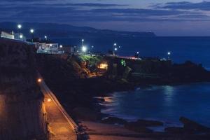 nacht lang blootstelling van witgekalkt gebouwen Aan de kust van Ericeira, Portugal foto