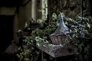 helderglazen fles in bruine rieten mand foto