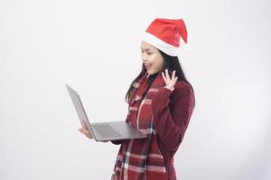 jonge lachende vrouw met rode kerstman hoed video-oproep foto