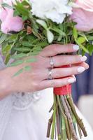 bruid hand- met een boeket en een ring Aan de ring vinger, detailopname. mooi bruiloft details foto