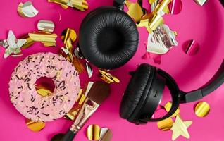 geschenk doos voor meisjes naar luister naar muziek- Aan koptelefoon. roze donut, hoofdtelefoons en bedenken borstel tussen de sparkles foto