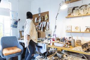 jong Latijns vrouw, in haar eigen schilderij studio, creëert schilderijen verschillend artistiek technieken foto