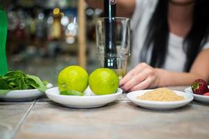 barman maken verfrissend coctail Aan een bar achtergrond. donker humeurig stijl. ijs in tha glas foto