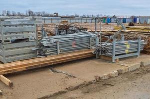 een veel van gebouw materialen met metaal Reserve onderdelen, stokken, balken, pijpen Bij een open lucht bouw plaats magazijn foto