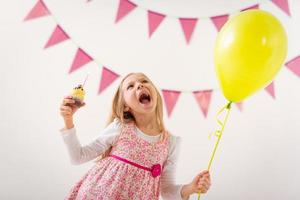 weinig meisje met ballon en koekje foto