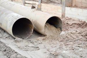 groot ijzer metaal riool loodgieter pijpen van groot diameter voor de industrieel bouw van water levering of riolering Bij een bouw plaats gedurende de reparatie foto